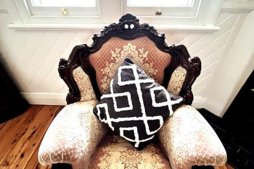 an old chair with pillows on top of it at My Cottage On Main in Boolaroo