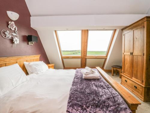 ein Schlafzimmer mit einem Bett mit zwei Handtüchern darauf in der Unterkunft Primrose Cottage in Ulverston