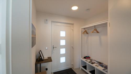 un pasillo con una puerta blanca y una ventana en LIBORIA: Stylisches Haus; Sauna ; 4min zum See, en Seehausen am Staffelsee