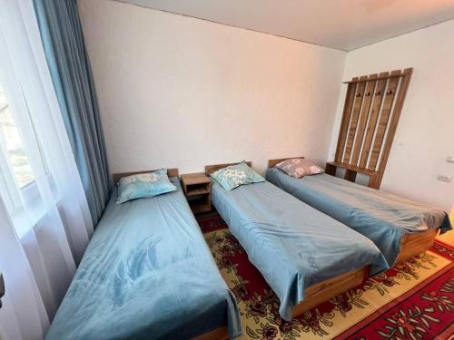 a room with two beds and a table at Гостевой дом KOLSAY ROOM in Saty