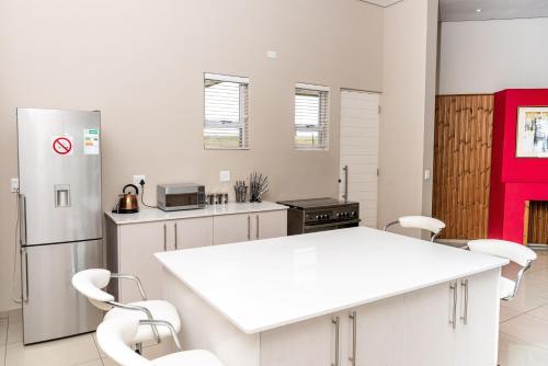 a kitchen with a white counter and white appliances at 36 Emanzini (Holiday home lake view) in Denysville