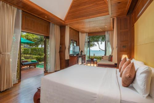 a bedroom with a bed with a view of the ocean at Koh Chang Paradise Resort & Spa in Ko Chang