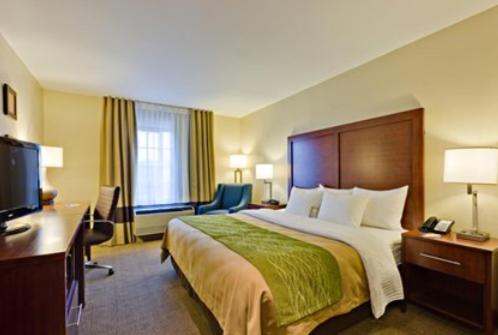 a hotel room with a large bed and a television at Comfort Inn & Suites in Caldwell