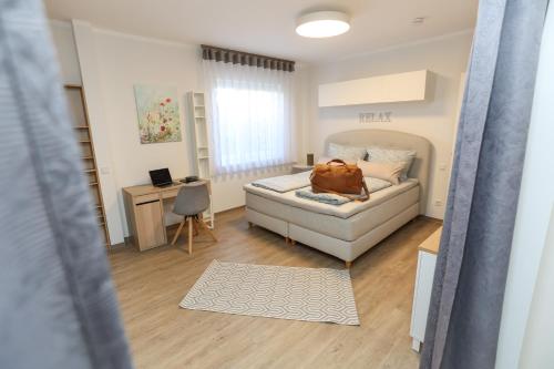 a bedroom with a bed and a desk with a chair at WEINQUARTIER Bad Kösen 65 qm Küche Parkplatz Terrasse Weinbergsblick in Naumburg
