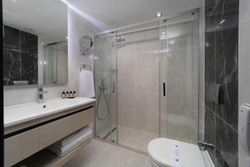 a bathroom with a shower and a sink and a toilet at Pianoforte by Febor Hotels&Spa in Istanbul