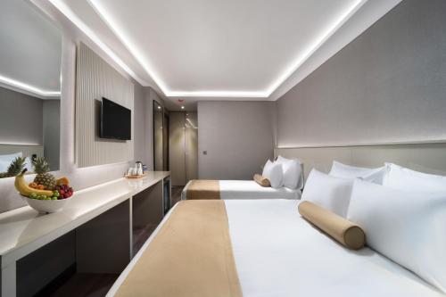 イスタンブールにあるPianoforte by Febor Hotels&Spaのベッド2台とデスクが備わるホテルルームです。