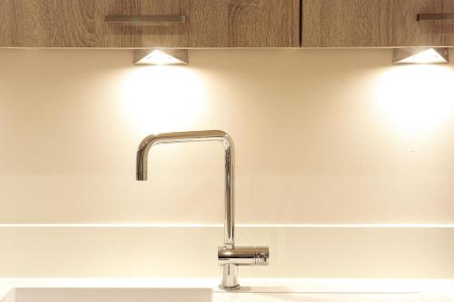 a kitchen sink with two lights on the wall at Condillac - Appartement 2 chambres avec ascenseur et Parking in Bordeaux