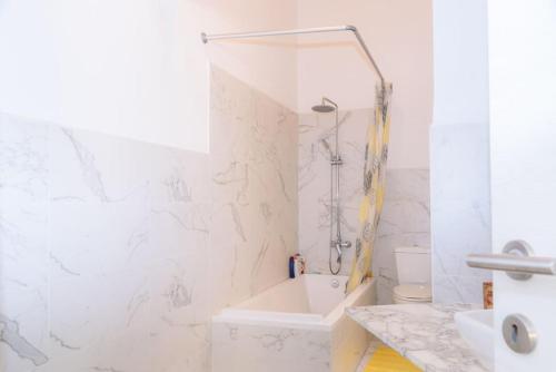 Baño blanco con bañera y lavamanos en Sliema Balluta 2 b/r apartment en Sliema