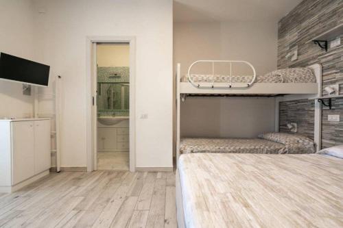 ein Schlafzimmer mit einem Etagenbett und einem TV. in der Unterkunft Free beach residence-Bungalow 1253 a 50mt dalla spiaggia in Costa Rei