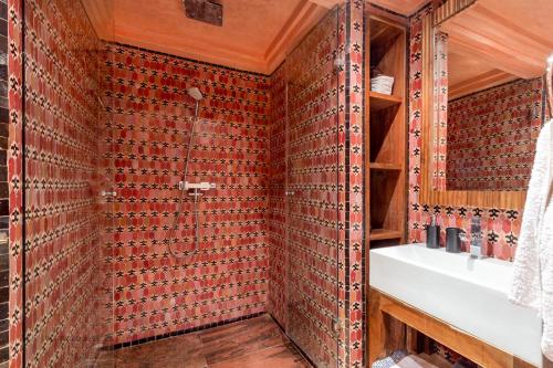 een badkamer met rode betegelde muren en een wastafel bij Appartement de luxe Hivernage Gueliz in Marrakesh