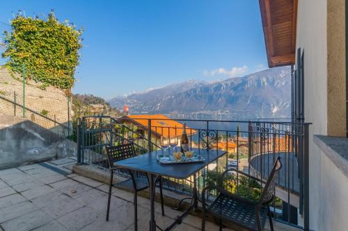 a table and chairs on a balcony with a view at Incanto Apartment by Wonderful Italy in Bellagio