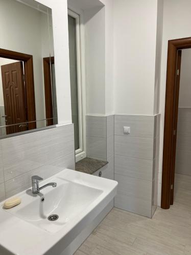 a bathroom with a white sink and a mirror at Apartmani prenj 1 i 2 centar in Konjic
