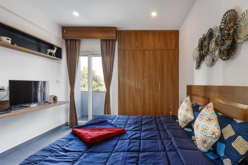 - une chambre avec un lit bleu et une télévision dans l'établissement Home Awaits 357, à Bangalore