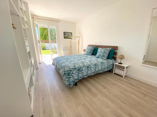 een slaapkamer met een bed met blauwe kussens erop bij Maison de vacances "L'Embrun Marin" in Brem-Sur-Mer