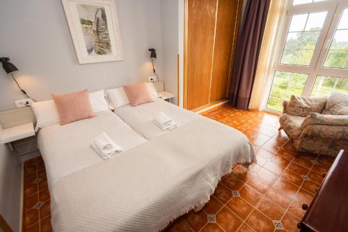 Un dormitorio con una cama y una silla y una ventana. en Apartamentos Cudillero, en Cudillero