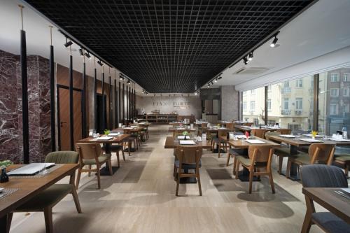 イスタンブールにあるPianoforte by Febor Hotels&Spaのダイニングルーム(木製のテーブルと椅子付)