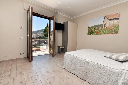 - une chambre avec un lit et une porte coulissante en verre dans l'établissement Relais Milò, à Agerola
