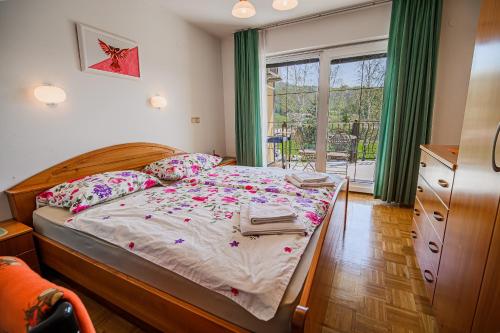 a bedroom with a bed with flowers on it at Apartments Vila Lena at Aqualuna in Podčetrtek