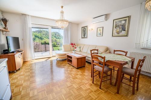 a living room with a table and a couch at Apartments Vila Lena at Aqualuna in Podčetrtek