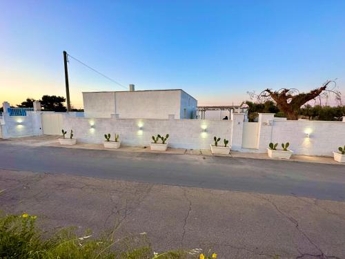 a white fence with potted plants on the side of a street at Villa Santo Stefano in Monopoli
