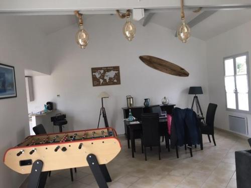 um quarto com uma mesa de pingue-pongue e uma sala de jantar em Gite avec piscine privative em LʼAiguillon-sur-Vie