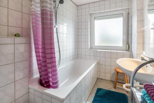 ein Badezimmer mit einer Badewanne und einem Waschbecken in der Unterkunft Ferienwohnung Villingen in Villingen-Schwenningen