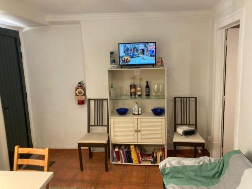 uma sala de estar com duas cadeiras e uma televisão numa prateleira em Special Suite Bairro Alto em Lisboa