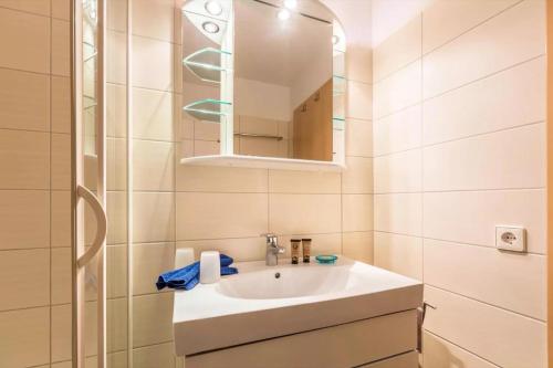 a white bathroom with a sink and a mirror at Haus der Gemütlichkeit in Konstanz