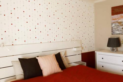 um quarto com uma cama e uma parede com pontos vermelhos em Hosszúhegyi Guesthouse em Pilisszántó