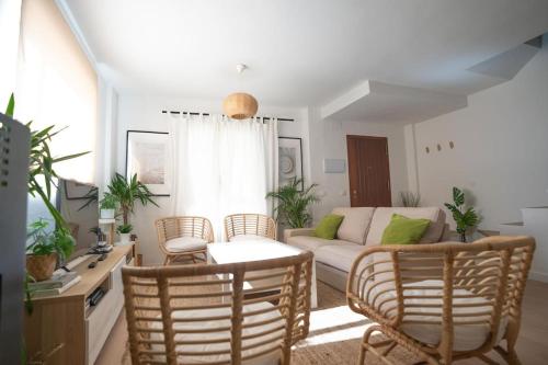 una sala de estar con un sofá y sillas en Casa en Tarifa en Primera linea de Playa, en Tarifa