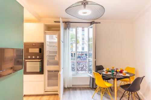 une cuisine et une salle à manger avec une table et des chaises jaunes dans l'établissement Charming apartment - 1BR-4P - Bastille, à Paris