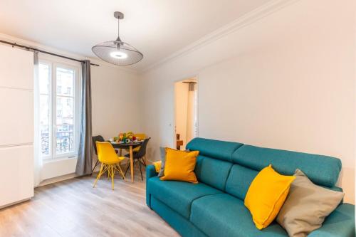 a living room with a blue couch and yellow pillows at Magnifique apartment au coeur de Nation - 4P1BR in Paris