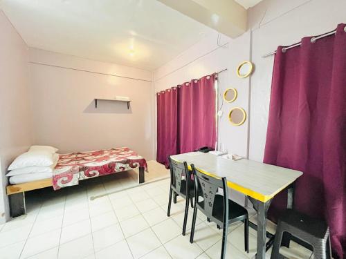 una camera con tavolo, letto e tende viola di The Cabin byTERBAIKhome a Città di Puerto Princesa