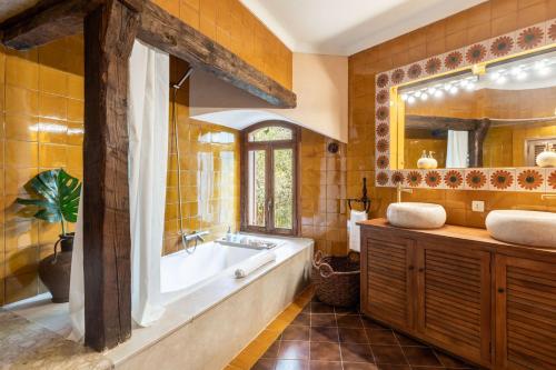 a bathroom with a tub and a sink and a mirror at Lovehaus Terra Rotja in Esporles