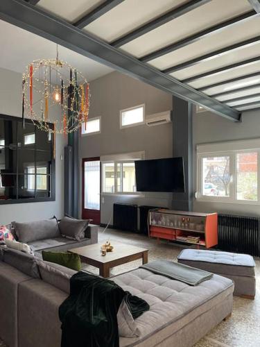 a living room with a couch and a tv at Πανέμορφο design,ηλιόλουστη ισόγεια μεζονέτα in Kastoria