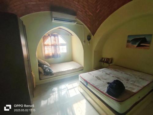 a bedroom with two beds in a room with a window at Touha House in Fayoum
