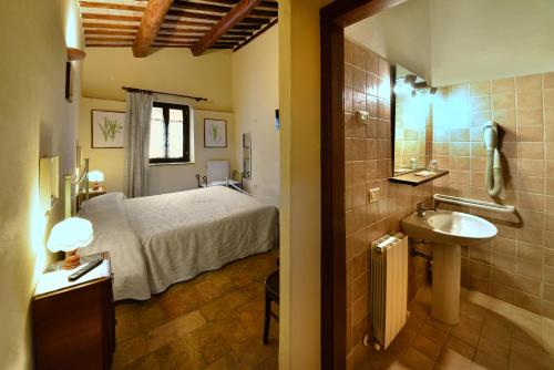 a bathroom with a bed and a sink in a room at Agriturismo Sasso Rosso in Capodacqua