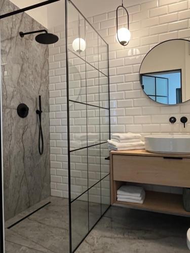 a bathroom with a glass shower and a sink at Penthouse Apartment mit Meerblick und Dachterrasse in Gaski bei Mielno in Gąski
