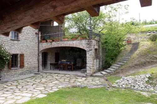 a stone house with a patio with a table at Ca' Növa in Valverde Pavia
