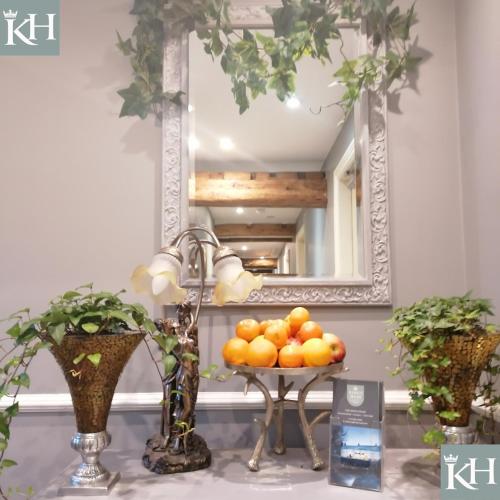a bowl of oranges on a table in front of a mirror at Kings Head - Riverside, Ravenstonedale in Ravenstonedale
