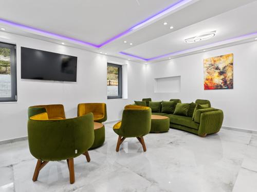 a living room with green chairs and a couch at Transylvania House in Arieşeni