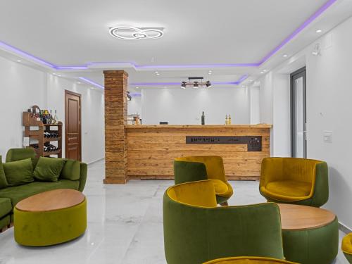 a lobby with green and yellow chairs and a counter at Transylvania House in Arieşeni