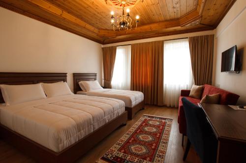 a hotel room with two beds and a chandelier at Rose Garden Hotel in Gjirokastër