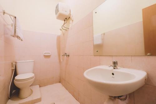 uma casa de banho com um lavatório, um WC e um espelho. em PIA Hotel Medan em Medan