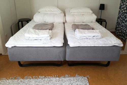 two beds sitting next to each other in a room at Vindsvåning, stenkast från centrum in Pietarsaari