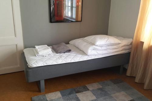 a bed with white sheets and towels on top of it at Vindsvåning, stenkast från centrum in Pietarsaari
