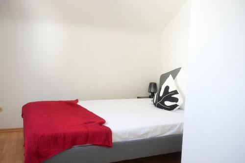 - une chambre avec un lit et une couverture rouge dans l'établissement Exklusive Stadtoase mit Panoramablick nähe Hauptbahnhof, à Coblence
