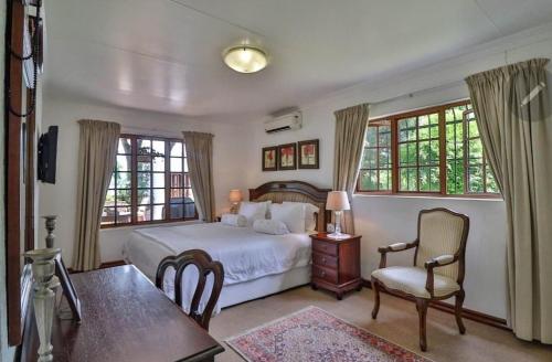 a bedroom with a bed and a table and chairs at 147@ Simon Bekker Kosmos in Hartbeespoort