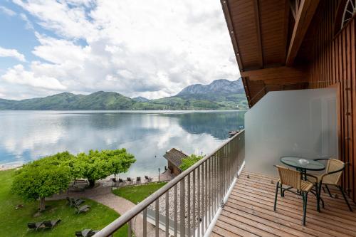 a balcony with a view of a lake and mountains at Hotel Stadler am Attersee in Unterach am Attersee