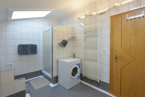 a bathroom with a washing machine and a washer at Klausner Kunterbunt in Volders